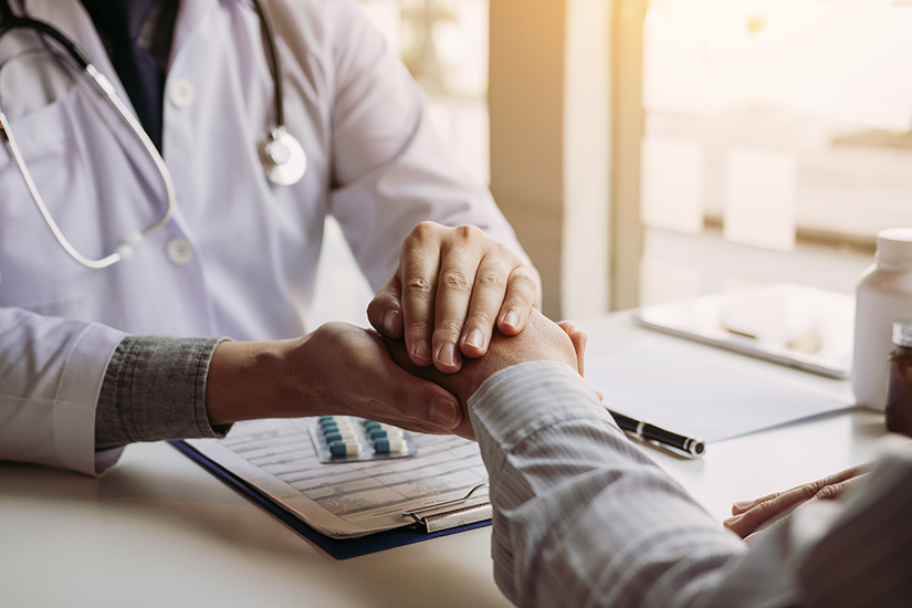 Pacient discută cu medicul psihiatru la birou, în timpul primei consultații psihiatrice