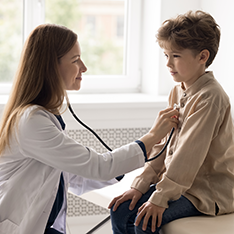 Medic examinând un copil cu stetoscopul
