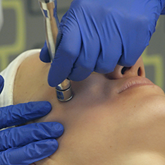 Medic efectuând o procedură dermato-cosmetică cu un aparat medical