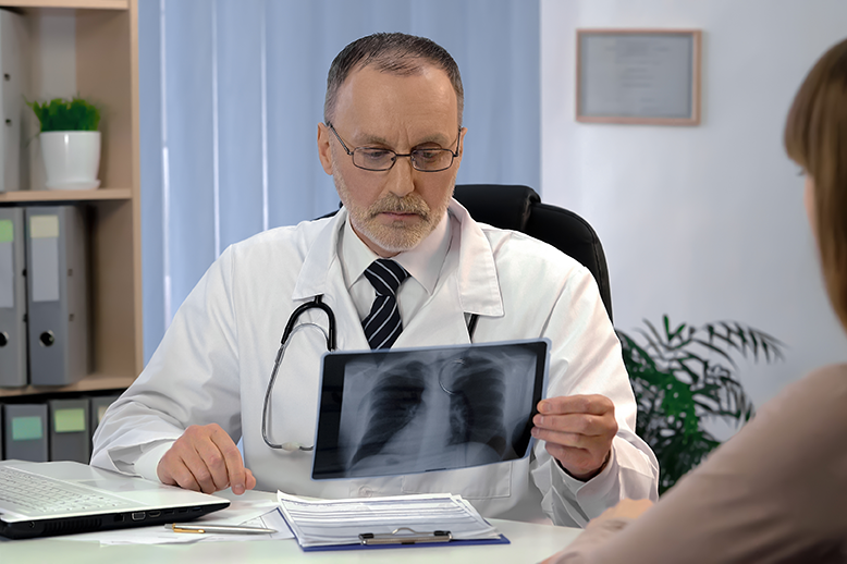 Medic pneumolog examinând o radiografie pulmonară pentru tuberculoză